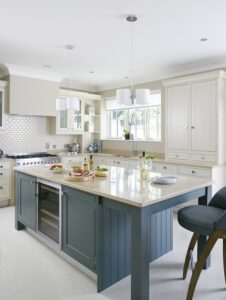 Spacious open-plan Shaker kitchen with a large island, featuring a blend of painted blue and white cabinetry with brushed aluminum accents.