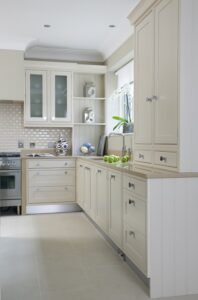 Bright and airy Shaker kitchen with Farrow & Ball painted cabinets in Stiffkey Blue and Wimborne White, illuminated by natural light.