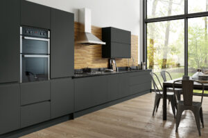 Modern kitchen design with matt graphite flat slab cabinets, integrated appliances, and wooden worktops.