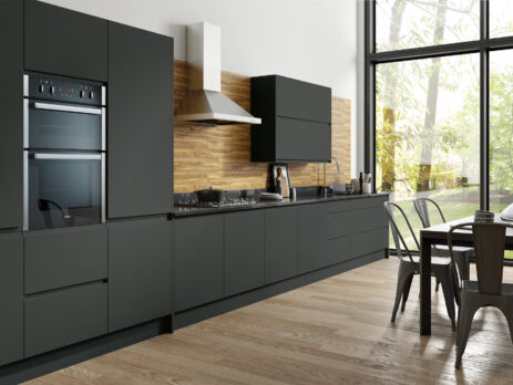 Modern kitchen design with matt graphite flat slab cabinets, integrated appliances, and wooden worktops.